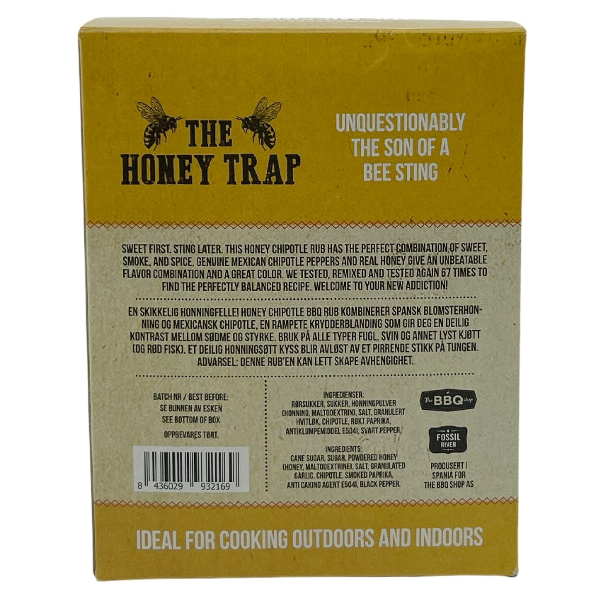 Baksiden av emballasjen til «The Missing Link Honey Trap BBQ Rub» med detaljert beskrivelse, strekkode, ingrediensliste og tilberedningstips for bruk både innendørs og utendørs. Inneholder den karakteristiske søte, røykfylte grillkrydderblandingen som gir en perfekt opplevelse av honning-chipotle-rub.