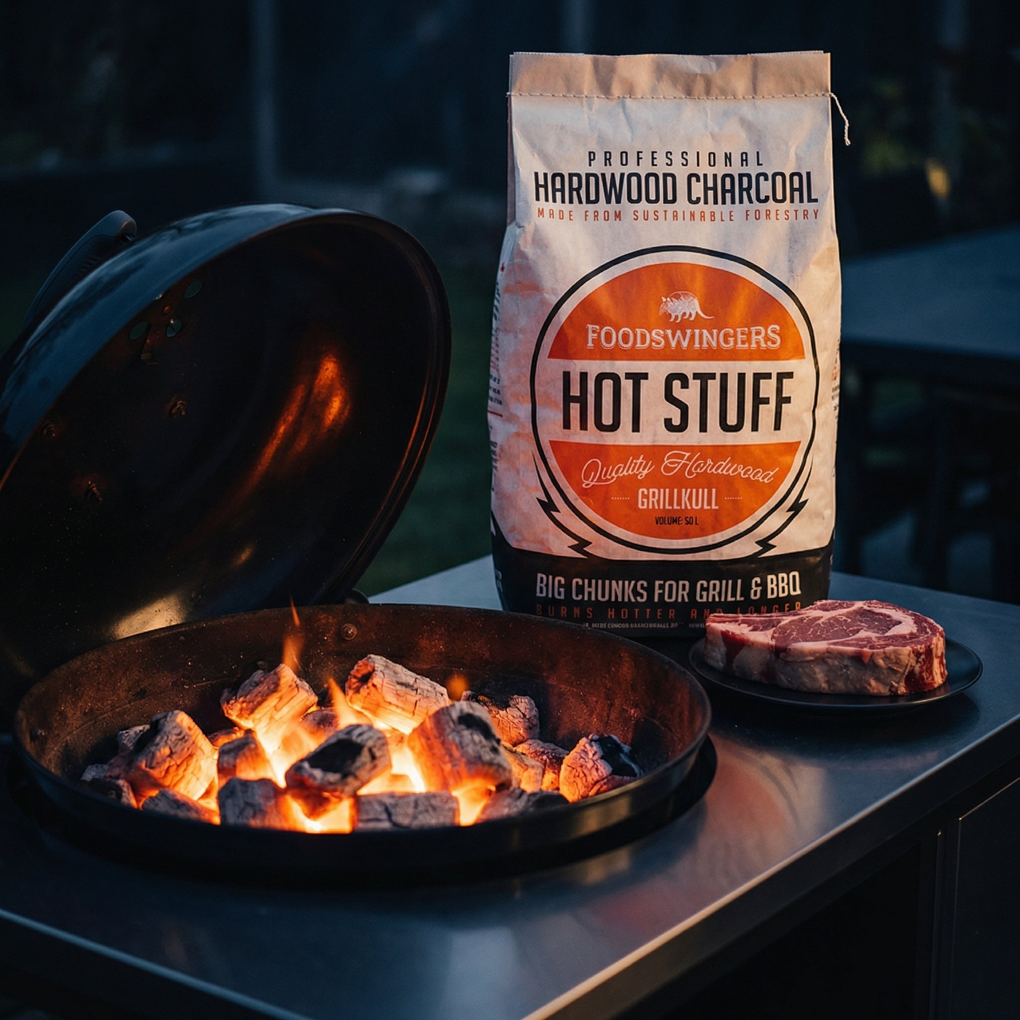 Grillkull "Hot Stuff" OAK FSC - 10 kg sekk ligger ved siden av en kullgrill og rå biff, perfekt for å oppnå grillsmak som på en restaurant med sertifisert trekull av eik.