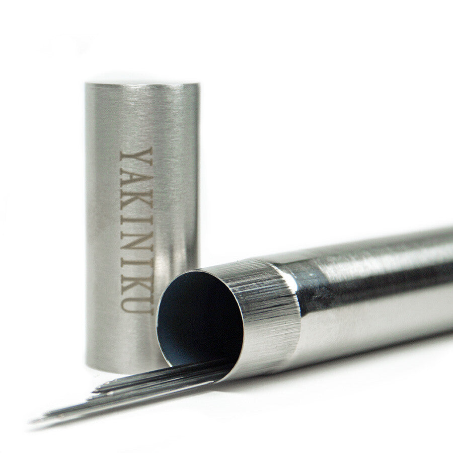 En metallbeholder merket YAKINIKU BBQ Spyd i Rustfritt Stål 1,0 mm 20stk inneholder flere tynne grillspyd i rustfritt stål, med lokket av og hvilende like ved på en hvit flate.