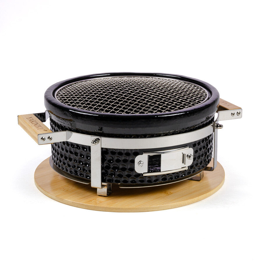 YAKINIKU Round Shichirin Japansk Bordgrill har en svart kropp, metallnettrist, trehåndtak og sokkel - perfekt for autentiske YAKINIKU-grillopplevelser.