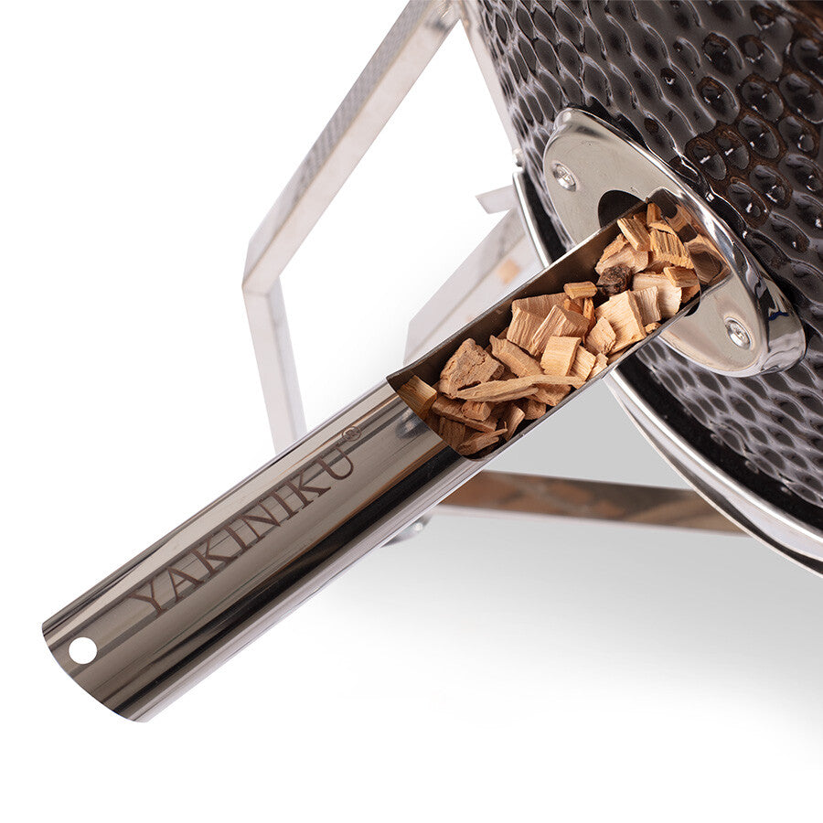 YAKINIKU Woodchipper, en metallskje fylt med treflis, settes inn i kamadogrillens spalte for å tilføre grillen rik røykaroma.