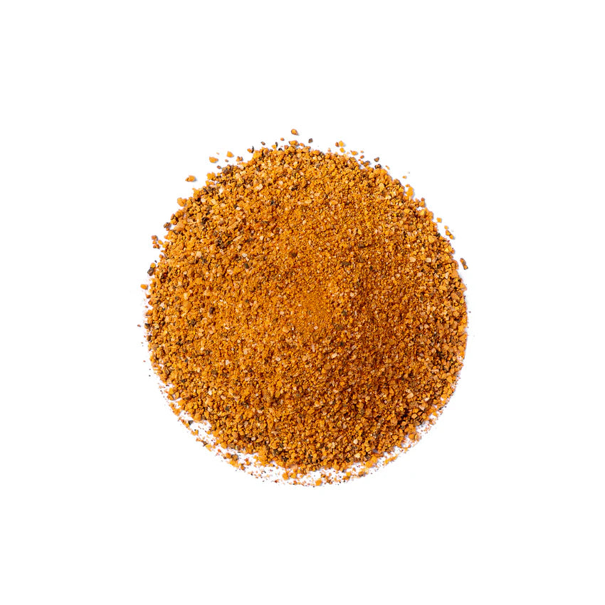 En liten haug med Sucklebusters BAMM! Sweet Heat BBQ Rub (404 g), malt til et oransjebrunt pulver, er lagt ut i en sirkel på en hvit bakgrunn.