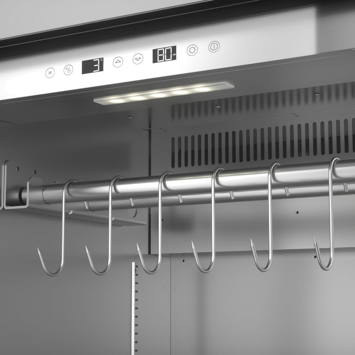 Nærbilde av interiøret i Caso DryAged Master 380 Pro tørrmodningsskap 380L, med overflate i rustfritt stål, digitalt kontrollpanel, LED-belysning og en solid metallstang med flere kjøttkroker – ideelt for presis tørrmodning.