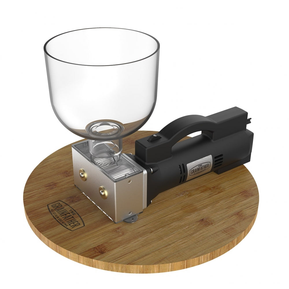 En svart håndholdt enhet festes til et omvendt vinglass på en rund trebase med Grainfather-merkevare, som ligner på Grainfather Electric Grain Mill - Maltmølle - Komplett Med Base.