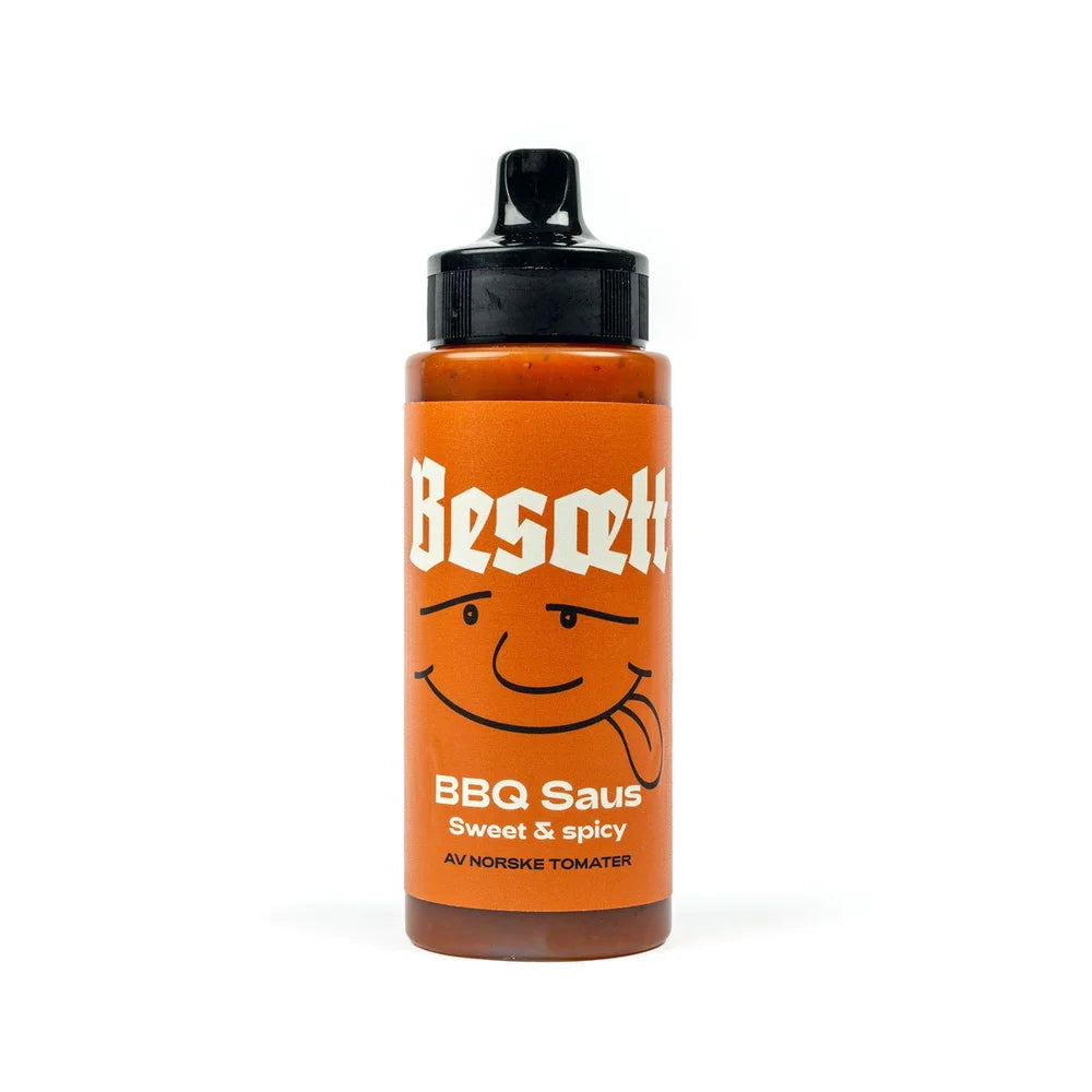 En flaske BBQ-saus fra Norske Tomater | Besætt, med en illustrasjon av et smilende ansikt og svart klemlokk – perfekt til grillmat og laget av norske tomater.