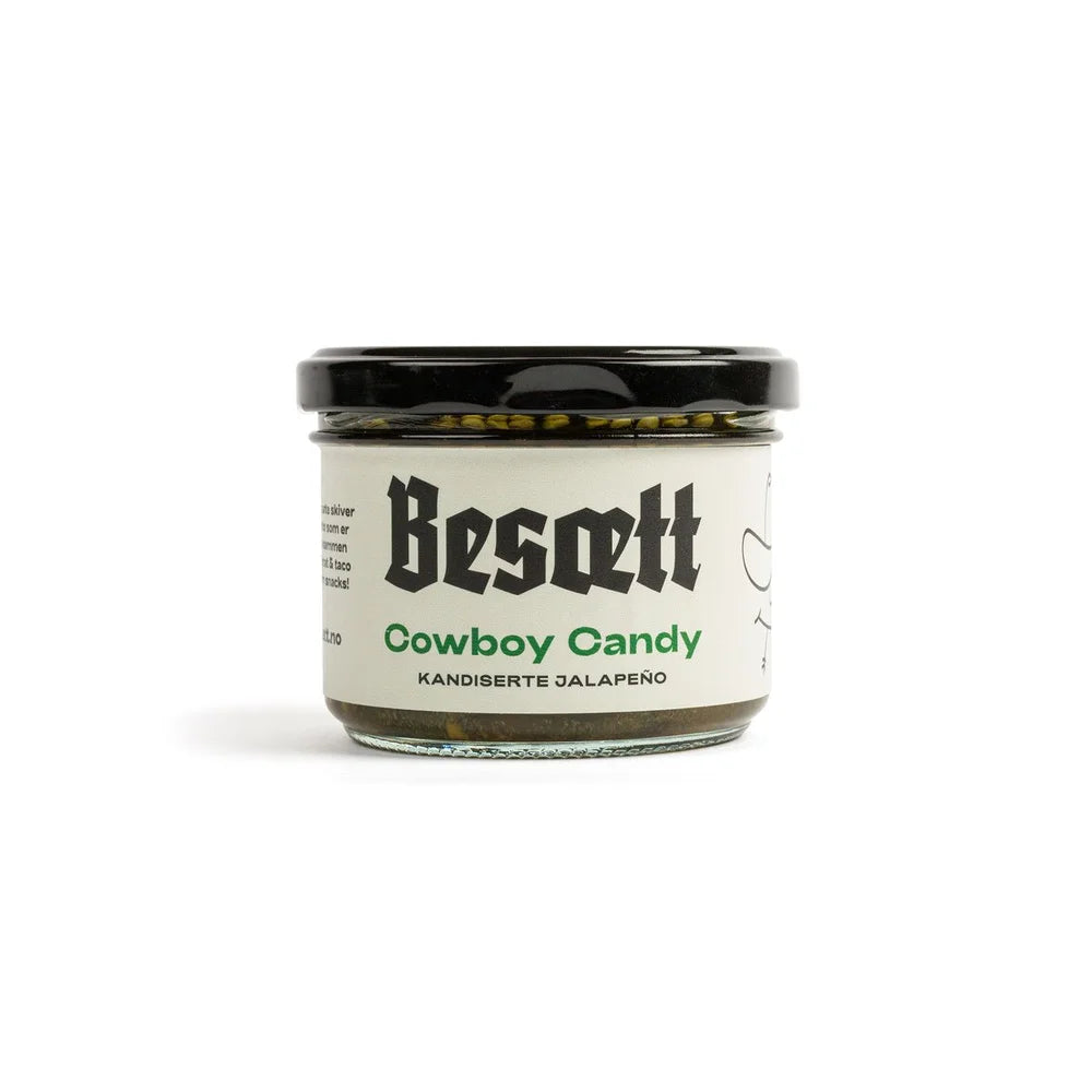 En glasskrukke med etiketten «Cowboy Candy – Sprø, Sterk & Søt | Besætt», som inneholder søt, sterk chili med kandiserte jalapeño, et svart lokk og en elegant hvit etikett.