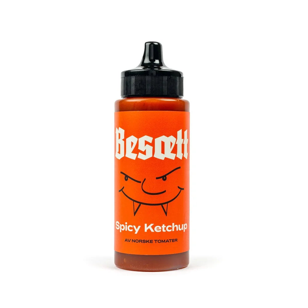 En flaske «Besætt Spicy Ketchup på Norske Tomater» med svart kork, oransje etikett og et tegneserieansikt på etiketten, med fet skrift som lyder «Spicy Ketchup på Norske Tomater» og fremhever den brennende habanero-smaken.
