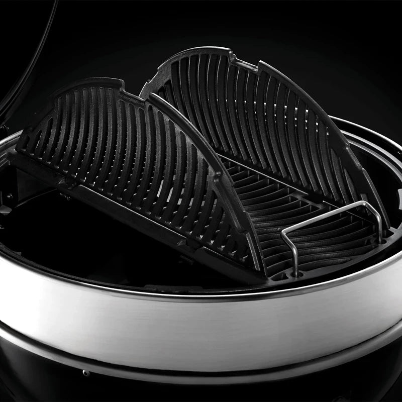 Et nærbilde av den svarte, todelte støpejernsristen inne i Napoleon PRO22 Kulegrill 57 cm - perfekt for grillentusiaster.
