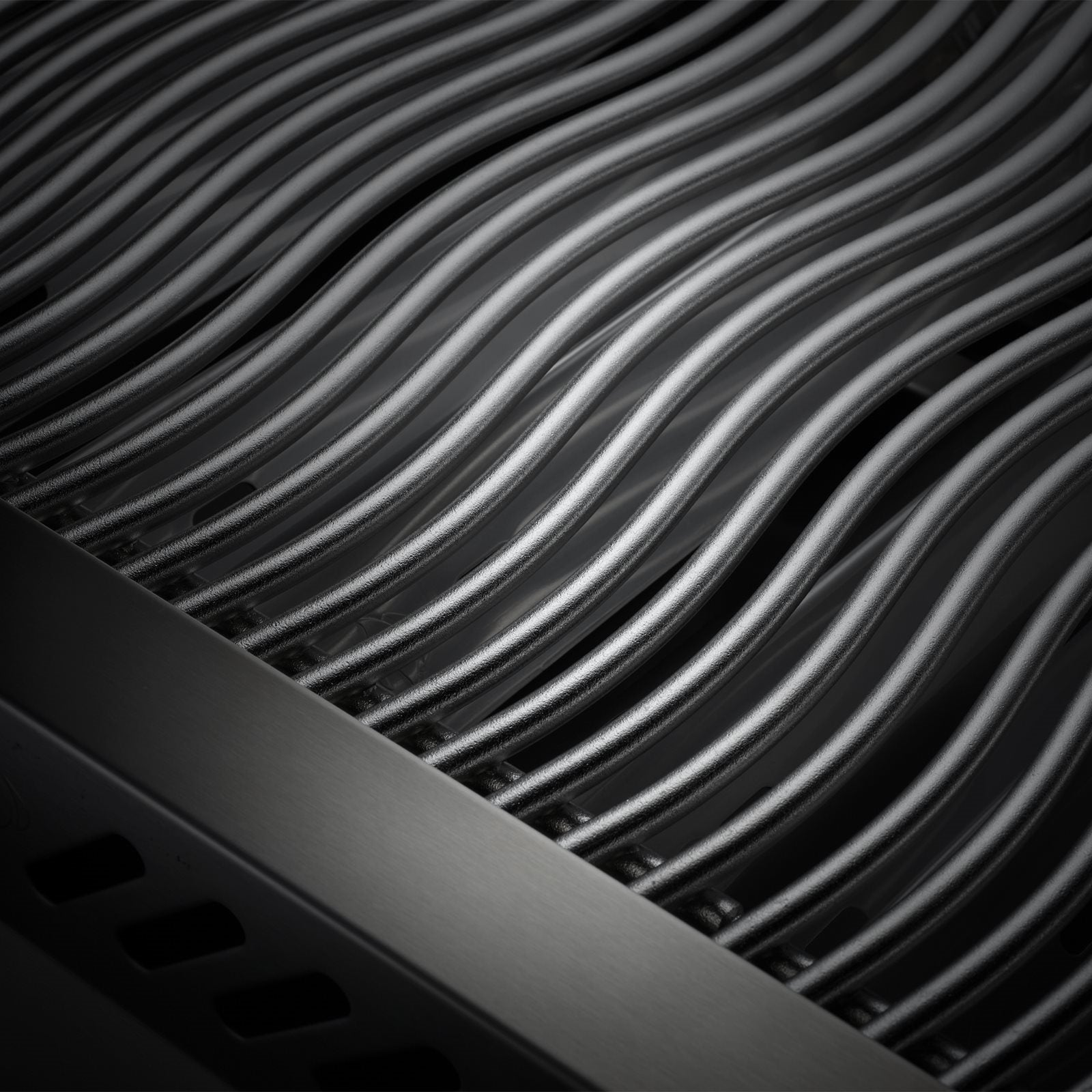 Nærbilde av mørke, bølgete metallstenger som er plassert parallelt på en Napoleon Built-in 700 Series 32" sort (Bestillingsvare), noe som skaper et slående mønster - perfekt for ethvert utekjøkken.