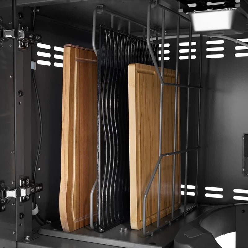 Skjærebrett av tre og sorte metallrister, som passer perfekt til en luksusgrill som Napoleon Prestige PRO™ 500 Connected (rustfritt stål/svart), oppbevares stående i et stativ inne i et skap.