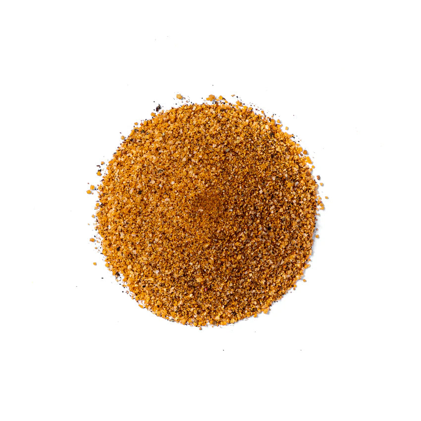 En rund haug med brunt og oransje kornet krydderblanding – Sucklebusters Hog Waller Pork Rub 390 g – er spredt ut på en hvit bakgrunn og sett ovenfra.