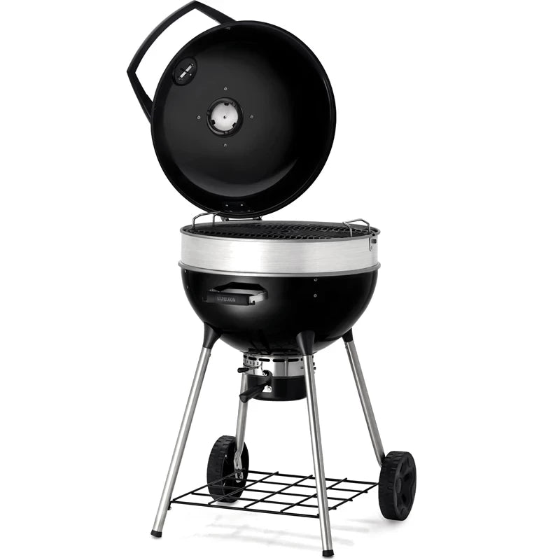 Napoleon PRO22 Kulegrill 57 cm i svart og sølv med åpent, rundt lokk, metallben, to hjul og en risthylle i bunnen.