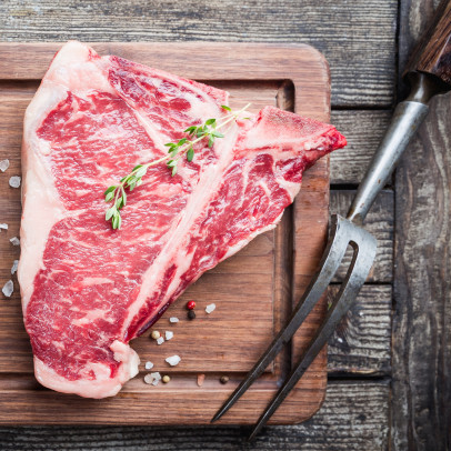 Storfe T-Bone Sashi Diamond 500g stykke på trefjøl med timian, grovt salt, pepperkorn og kjøttgaffel-et premium kjøttstykke anerkjent under World Steak Challenge.