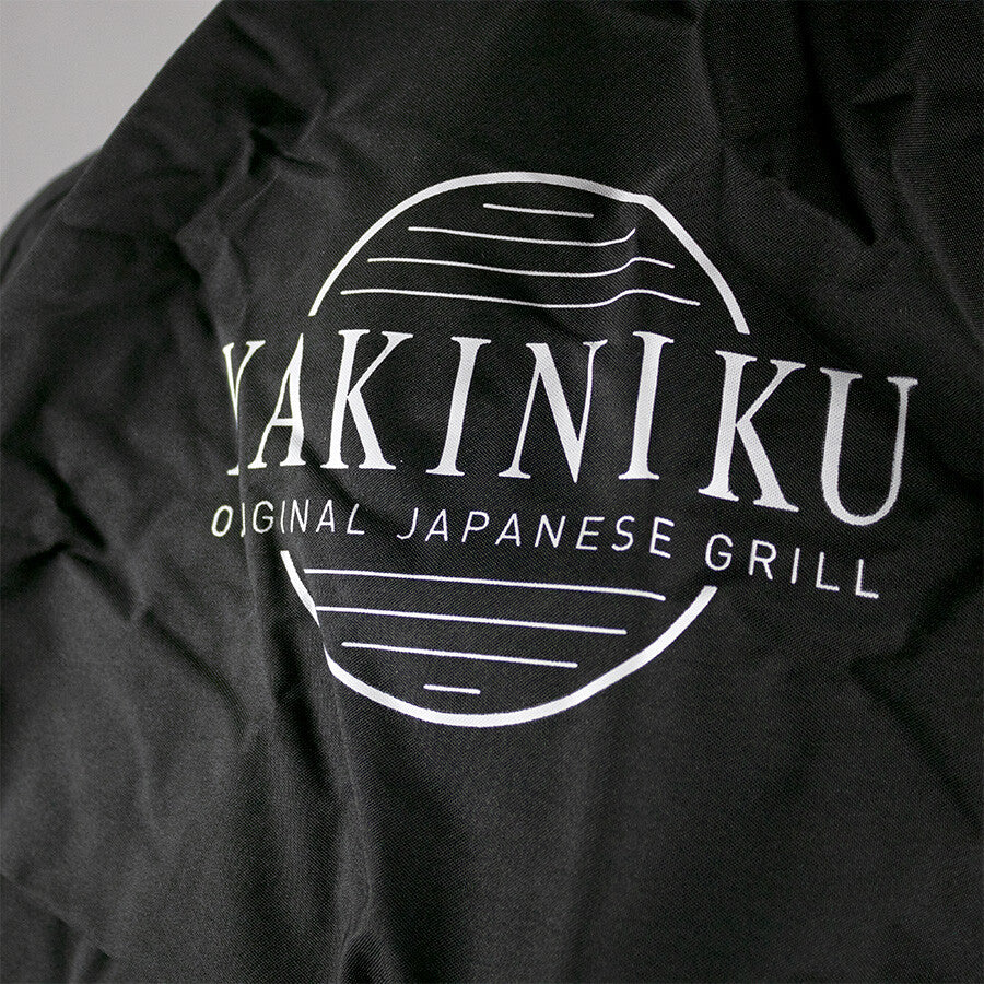 YAKINIKU Grilltrekk til XLARGE Kamado har svart stoff med en hvit sirkulær logo og teksten "YAKINIKU ORIGINAL JAPANESE GRILL", noe som gjør det til et stilig og beskyttende deksel for din XLARGE Kamado.