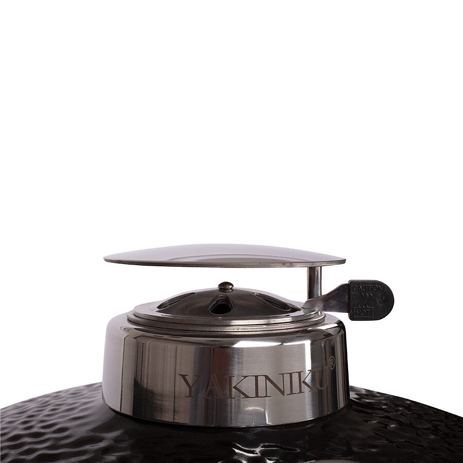 Nærbilde av en luftventil i rustfritt stål på toppen av en svart YAKINIKU Kamado Large Complete grillkuppel.