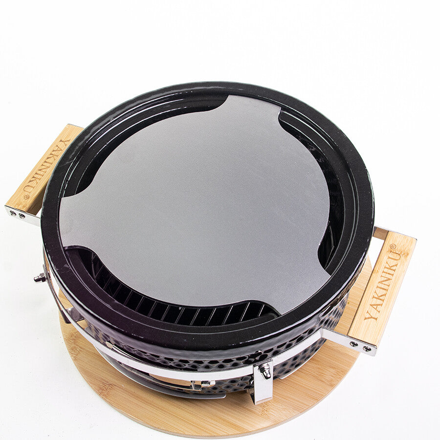 YAKINIKU Shichirin Teppanyaki Plate Rund, Medium er en rund bordgrill med flat stekeflate, YAKINIKU®-merkede trehåndtak og en trebunn, som vist ovenfra.
